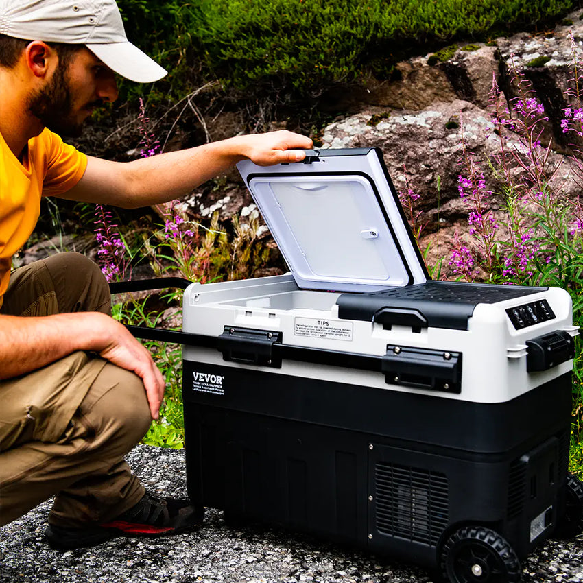 Ansicht des tragbaren elektrischen Kühlers mit Rollen im geöffneten Zustand während des Gebrauchs
